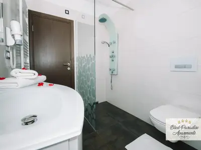 a white bathroom with a sink and a toilet at Bled Prestigious and Stylish Apartments - Two Bedroom Apartment with Balcony in Bled
