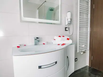 a bathroom with a white sink and a mirror at Bled Prestigious and Stylish Apartments - Two Bedroom Apartment with Balcony in Bled