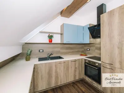 a kitchen with wooden cabinets and a sink at Bled Prestigious and Stylish Apartments - Two Bedroom Apartment with Balcony in Bled