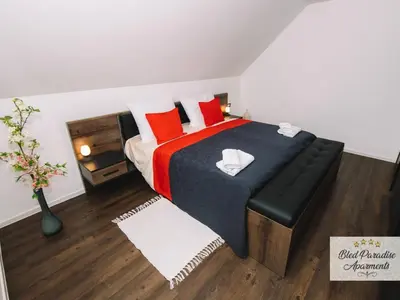 a bedroom with a large bed with red pillows at Bled Prestigious and Stylish Apartments - Two Bedroom Apartment with Balcony in Bled