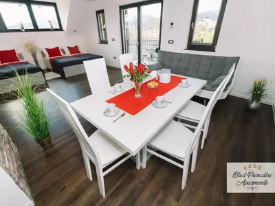 a dining room with a white table and chairs at Bled Prestigious and Stylish Apartments - Two Bedroom Apartment with Balcony in Bled