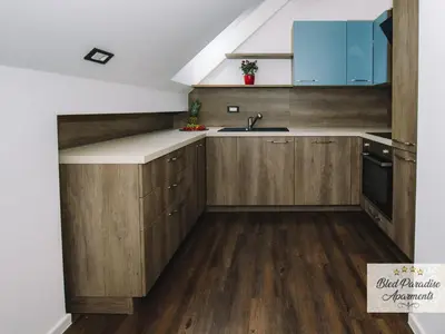 a kitchen with wooden cabinets and a sink at Bled Prestigious and Stylish Apartments - Two Bedroom Apartment with Balcony in Bled