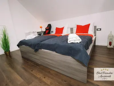 a bedroom with a large bed with red pillows at Bled Prestigious and Stylish Apartments - Two Bedroom Apartment with Balcony in Bled