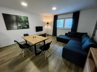 a living room with a blue couch and a table at Modern and Peaceful Apartment with Terrace - Two Bedroom Apartment with Terrace in Rečica ob Savinji