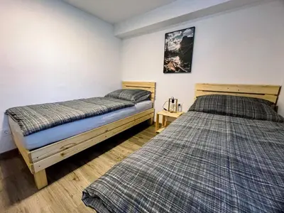 two beds sitting in a room with at Modern and Peaceful Apartment with Terrace - Two Bedroom Apartment with Terrace in Rečica ob Savinji