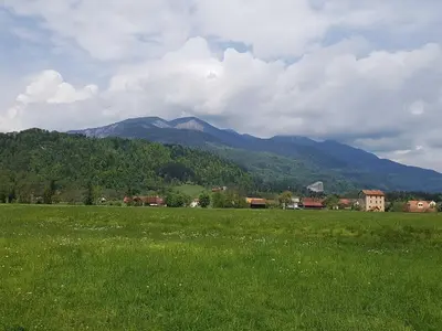 a field of green grass with a mountain in the background at Modern and Peaceful Apartment with Terrace - Two Bedroom Apartment with Terrace in Rečica ob Savinji