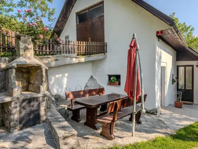 a patio with a wooden bench and an umbrella at Nature Hideaway Holiday Homes with Sauna - Two Bedroom Holiday Home in Slappe dʼIdria