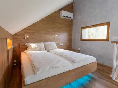 a large bed in a room with a window at Elegant Warm Bliss Hideaway Escape Lodge - Holiday Home with Hot-Tub in Šenčur