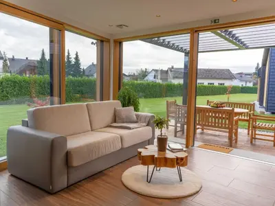 a living room with a couch and a table at Elegant Warm Bliss Hideaway Escape Lodge - Holiday Home with Hot-Tub in Šenčur