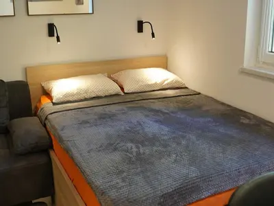 a small bed in a room with a couch at Cozy and Chic Apartment in Kranjska Gora - Studio Apartment in Kranjska Gora
