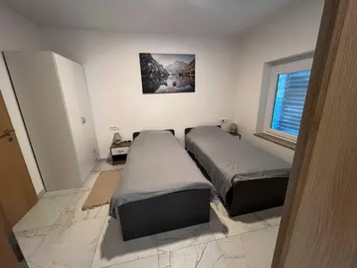 a bedroom with two beds and a window at Delightful Cozy Riverside Apartment - One Bedroom Apartment with Terrace in Rečica ob Savinji