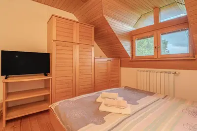 a bedroom with a bed and a flat screen tv at Oblak Estate Apartments in Ortnek