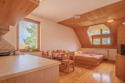 a kitchen with wooden ceilings and a table and chairs at Oblak Estate Apartments in Ortnek