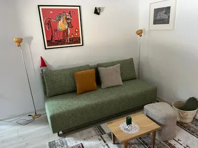 a living room with a green couch and a table at Triglav NP Apartment - above Bled in Zgornje Gorje