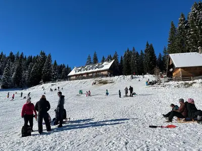 a group of people in the snow near a ski lodge at Triglav NP Apartment - above Bled in Zgornje Gorje