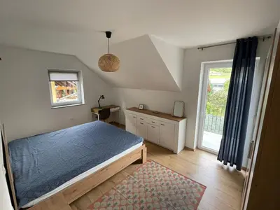 a bedroom with a blue bed and a window at Spacious 2 bed Villa near Spa Town Rogaska Slatina in Rogaška Slatina