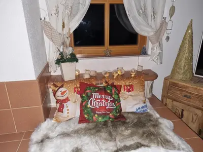 a group of christmas pillows on a bed with a window at Rupicapra Holiday Mountain House in Kostel