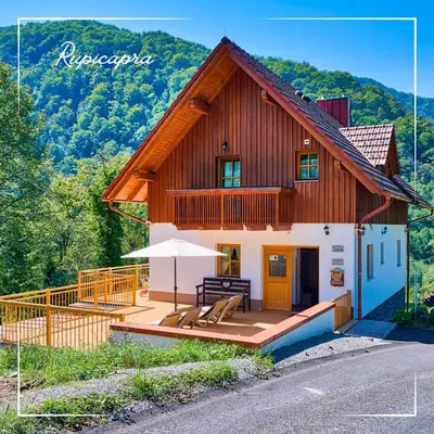 a house with a deck with an umbrella at Rupicapra Holiday Mountain House in Kostel
