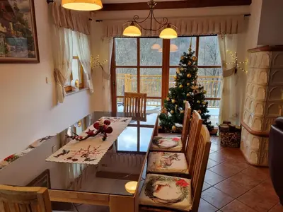a dining room with a table and a christmas tree at Rupicapra Holiday Mountain House in Kostel
