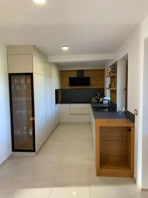 a kitchen with white cabinets and a black counter top at Hiša nad izvirom reke Krke in Krka