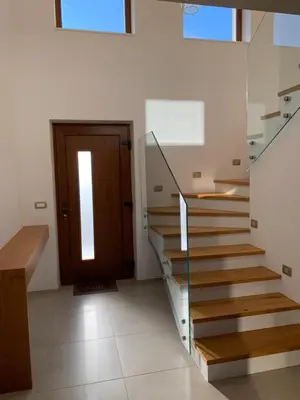 a staircase in a house with a wooden door at Hiša nad izvirom reke Krke in Krka