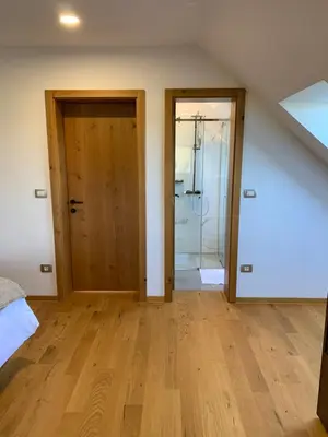 an attic room with two doors and wooden floors at Hiša nad izvirom reke Krke in Krka