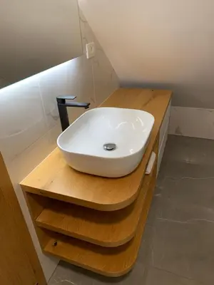 a white sink on a wooden counter in a bathroom at Hiša nad izvirom reke Krke in Krka