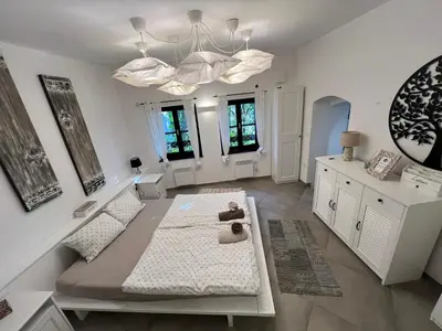 a living room with white walls and a chandelier at City Center Deluxe in Kranj