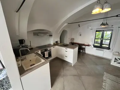 a kitchen with white cabinets and a table in it at City Center Deluxe in Kranj