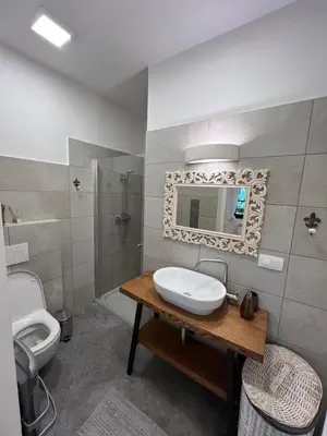 a bathroom with a sink and a toilet and a mirror at City Center Deluxe in Kranj