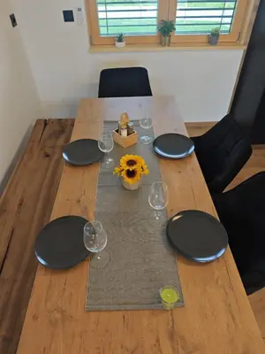a wooden table with wine glasses and a sunflower on it at RANČ Dida