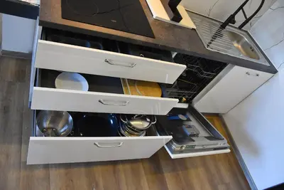 an open refrigerator with white drawers in a kitchen at Apartma Fontana in Ljubljana