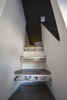 a staircase in a house with white walls and a black ceiling at Apartma Fontana in Ljubljana