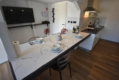 a kitchen with a large white counter with a table at Apartma Fontana in Ljubljana