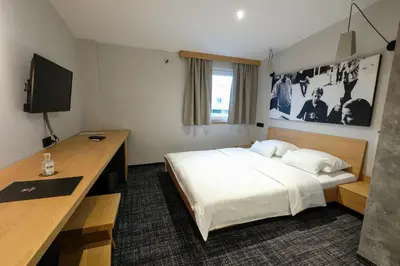 a hotel room with a bed and a desk with a computer at Hotel Kunst in Krško