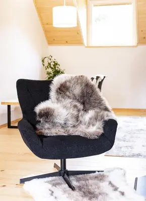 a black chair with a faux fur blanket on it at TDI - Modern 2-Bedroom Apartment in nature