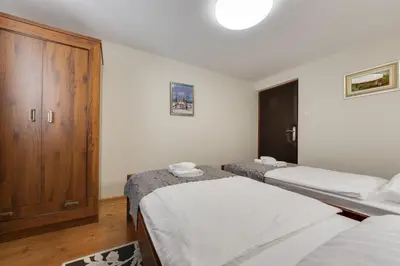 a bedroom with two beds and a wooden cabinet at Lake Bled Holiday Home in Bled