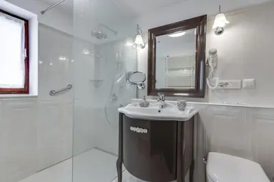 a white bathroom with a sink and a shower at Lake Bled Holiday Home in Bled