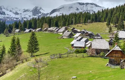 a group of cottages on a hill with mountains at Lake Bled Holiday Home in Bled
