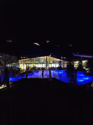 a building lit up at night with blue lights at Apartman O Terme Olimia in Ravne na Koroškem