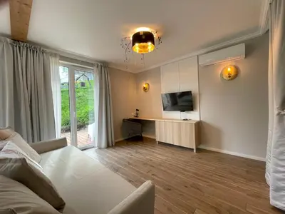 a living room with a white couch and a television at Alpennelke family apartment in Bohinjska Bela
