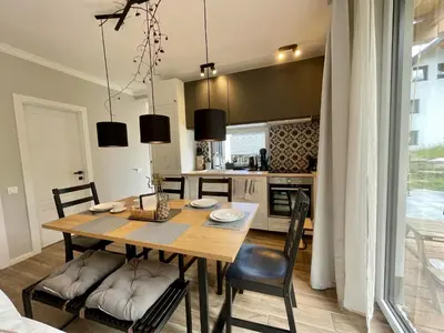 a kitchen and dining room with a wooden table and chairs at Alpennelke family apartment in Bohinjska Bela