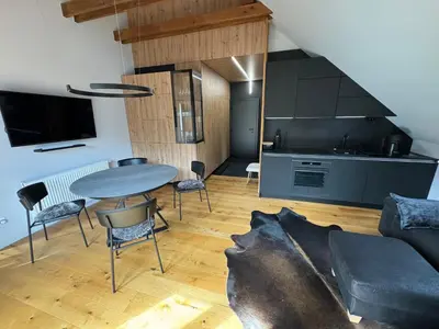 a living room with a table and a kitchen at Apartment Kranjska Gora Diamond in Kranjska Gora