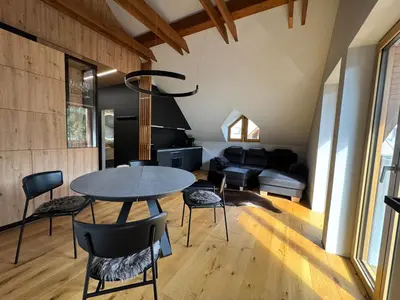 a kitchen and living room with a table and chairs at Apartment Kranjska Gora Diamond in Kranjska Gora