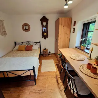a bedroom with a bed and a table and a clock at Atelje Mlin Umetnin Retreat in Šentjur