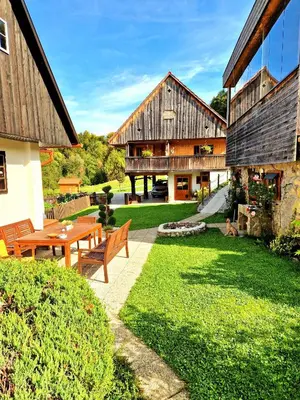 a house with a table and benches in a yard at Atelje Mlin Umetnin Retreat in Šentjur