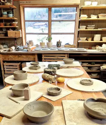 a room with bowls and other ceramics on a table at Atelje Mlin Umetnin Retreat in Šentjur