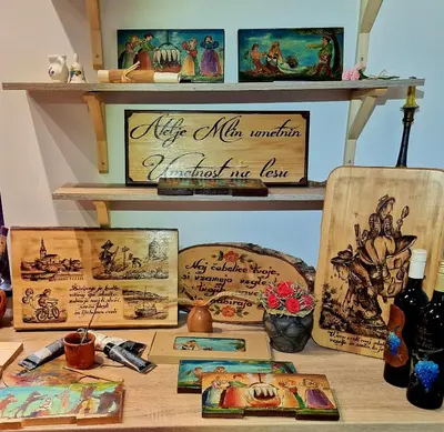 a table with paintings and other items on a shelf at Atelje Mlin Umetnin Retreat in Šentjur