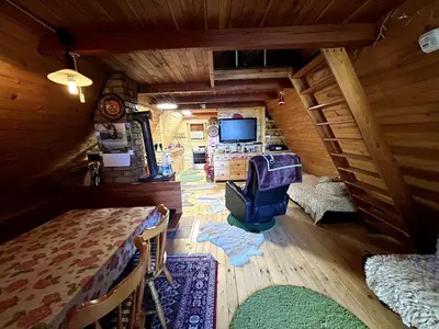 an attic room with a tv and a table at The house at the larssen in Šmartno pri Slovenj Gradcu