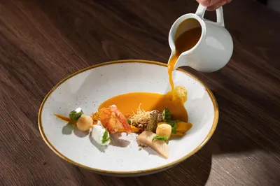 a plate of food with sauce being poured on it at Gostišče Iršič in Slovenska Bistrica
